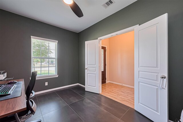 office space featuring visible vents, a ceiling fan, baseboards, and dark tile patterned flooring