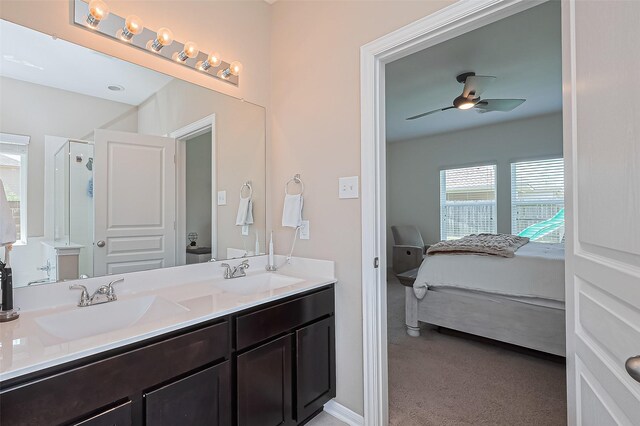ensuite bathroom with connected bathroom, ceiling fan, a sink, and a stall shower