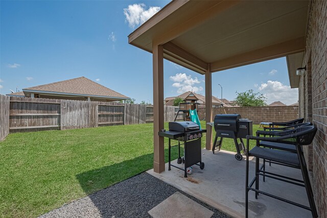 view of yard featuring a patio, a fenced backyard, and a playground