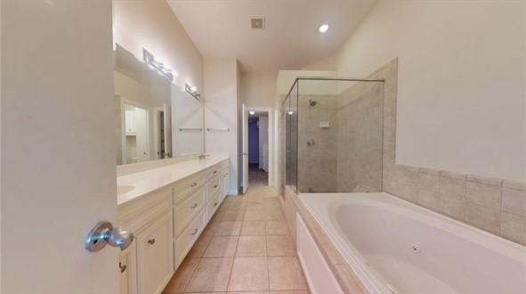 bathroom with double vanity, a bath, vaulted ceiling, a shower stall, and tile patterned floors