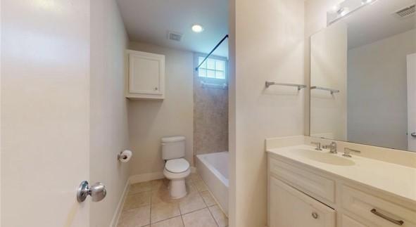 bathroom featuring vanity, tile patterned flooring, visible vents, toilet, and baseboards
