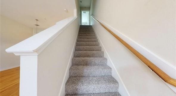 staircase with baseboards and wood finished floors