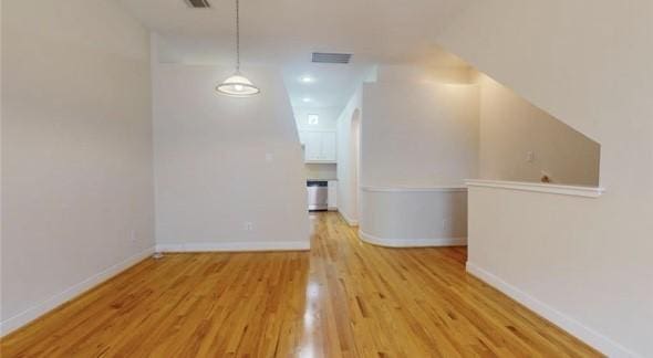 bonus room featuring baseboards, wood finished floors, and visible vents