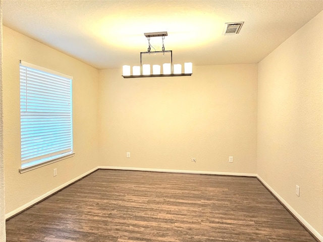 empty room featuring dark wood-style flooring and baseboards