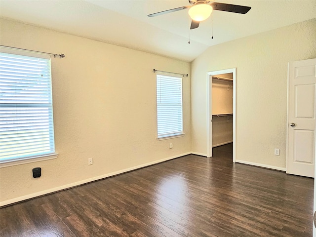 unfurnished bedroom with wood finished floors, multiple windows, vaulted ceiling, and baseboards