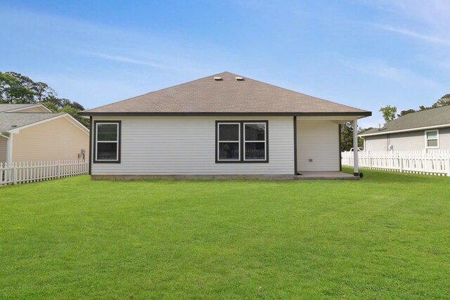 back of property featuring a yard, a patio, a shingled roof, and fence private yard