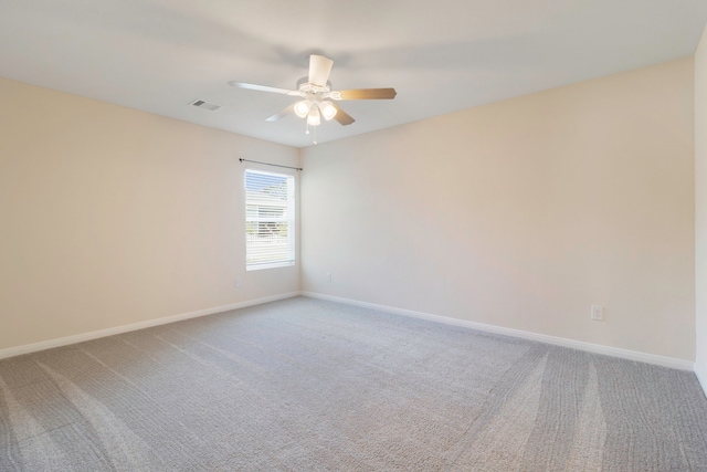 carpeted empty room featuring visible vents, baseboards, and ceiling fan
