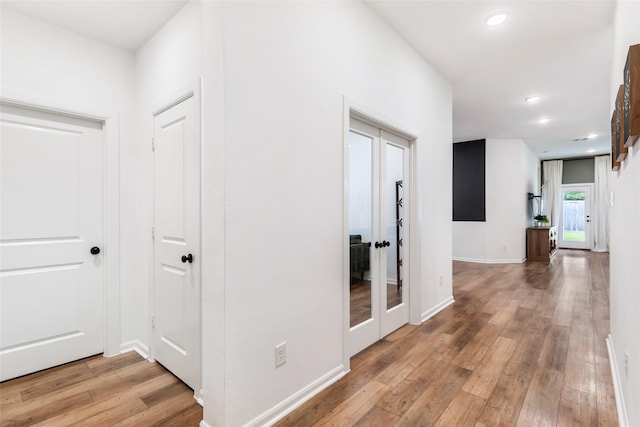 corridor with recessed lighting, light wood finished floors, and baseboards