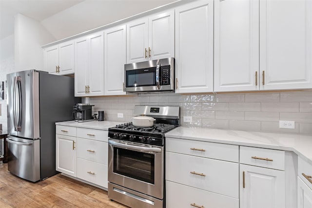 kitchen featuring white cabinets, stainless steel appliances, light wood-style floors, and tasteful backsplash