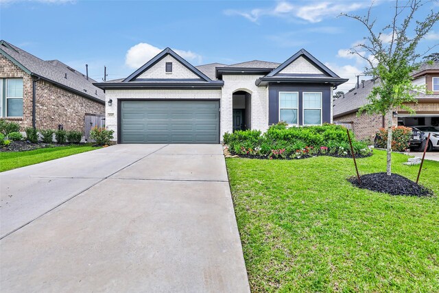 ranch-style home featuring brick siding, driveway, a front yard, and a garage