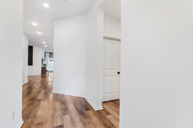 hallway with recessed lighting, baseboards, and wood finished floors