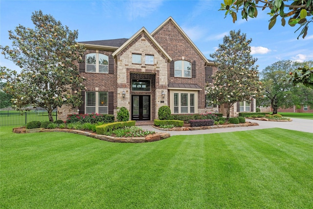 view of front facade featuring french doors, fence, a standing seam roof, and a front yard