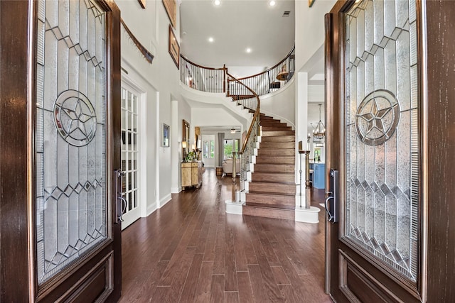 entryway with stairs, a towering ceiling, baseboards, dark wood-type flooring, and recessed lighting