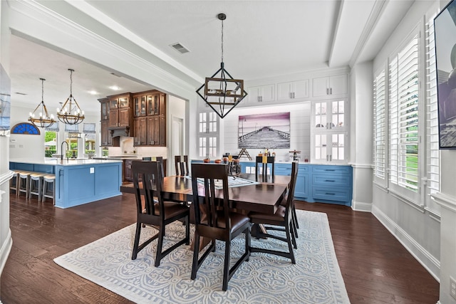 dining area with baseboards, ornamental molding, dark wood-style flooring, and a notable chandelier