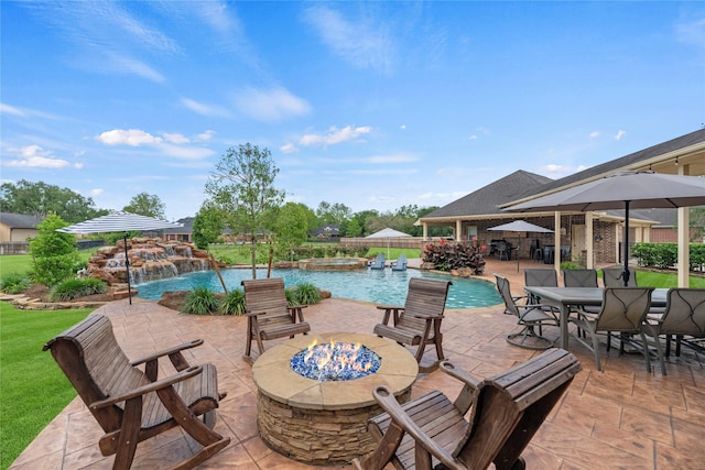 view of patio / terrace featuring a pool with connected hot tub, a fire pit, and outdoor dining space