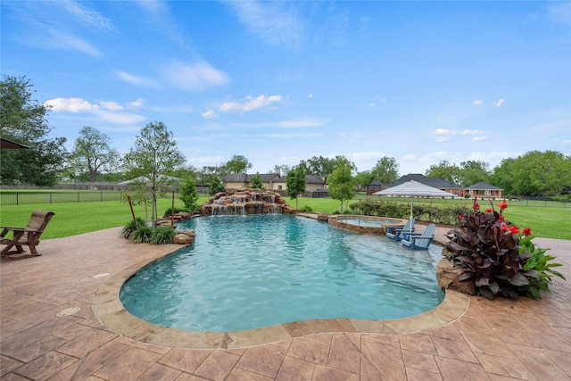 view of swimming pool featuring a patio, fence, a yard, and a pool with connected hot tub