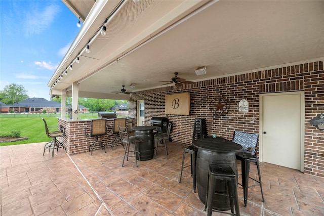 view of patio / terrace featuring a ceiling fan, fence, outdoor dry bar, and outdoor dining space