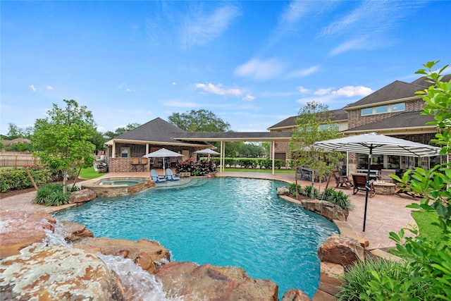 view of pool with a patio area, a pool with connected hot tub, and fence