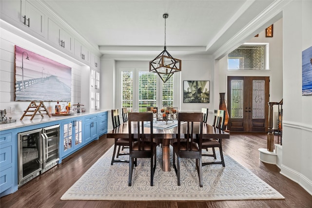 dining area with dark wood-style flooring, baseboards, a chandelier, wine cooler, and a tray ceiling