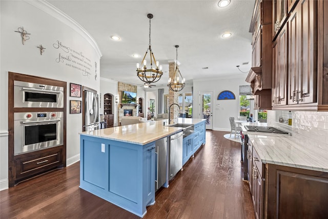 kitchen featuring an inviting chandelier, crown molding, recessed lighting, a sink, and appliances with stainless steel finishes