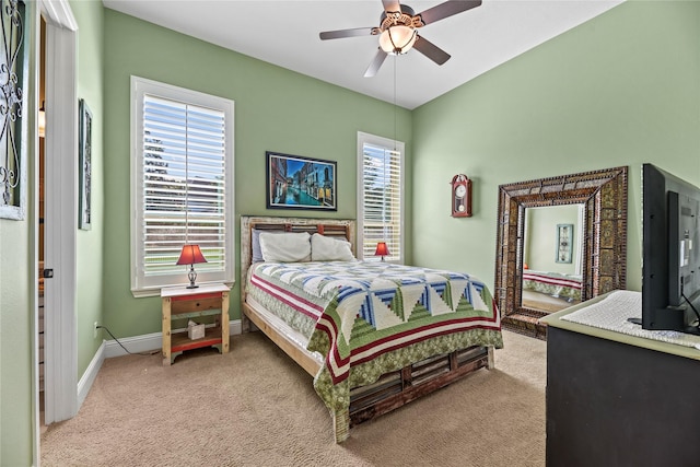 carpeted bedroom featuring baseboards, a ceiling fan, and multiple windows