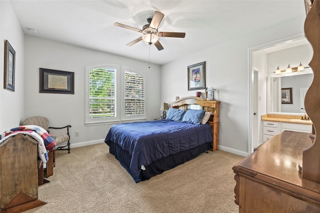 bedroom featuring connected bathroom, a ceiling fan, baseboards, and light colored carpet