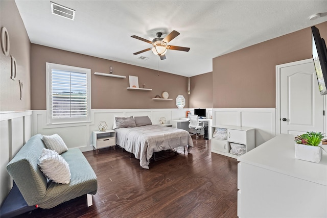 bedroom featuring visible vents, wood finished floors, and a wainscoted wall