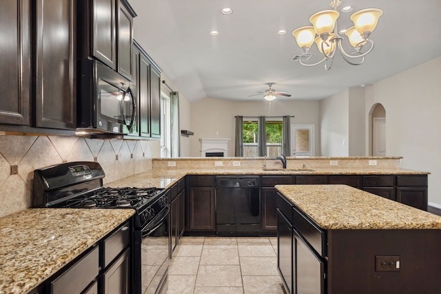 kitchen with a sink, arched walkways, ceiling fan with notable chandelier, backsplash, and black appliances