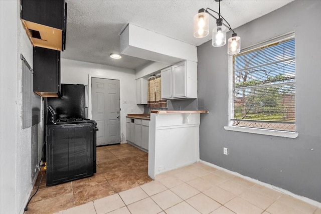 6201 Batterson St, Houston, TX 77026 - kitchen with range, a textured ceiling, white cabinetry, baseboards, and light tile patterned floors