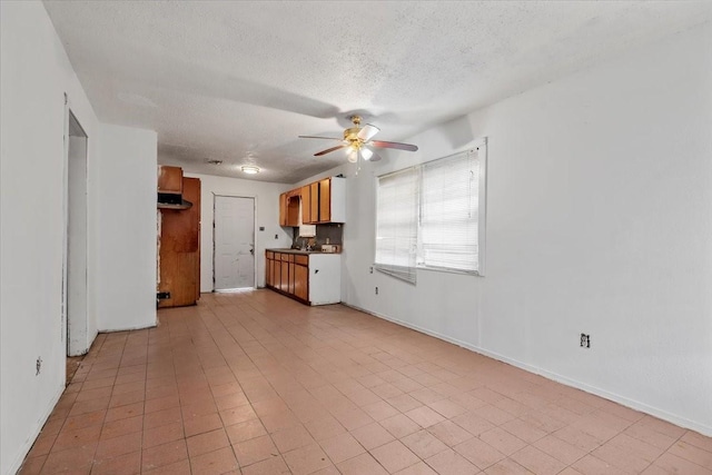 6201 Batterson St, Houston, TX 77026 - unfurnished living room with a ceiling fan, a textured ceiling, and baseboards