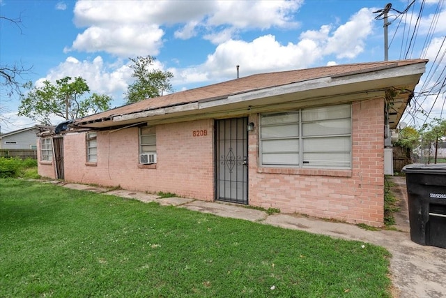 6201 Batterson St, Houston, TX 77026 - rear view of property featuring brick siding, a yard, and cooling unit