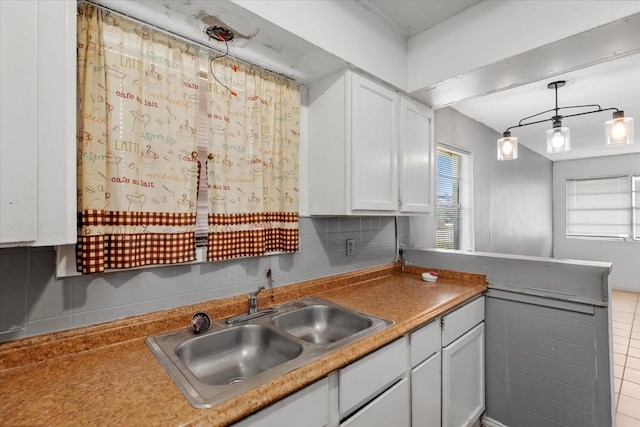 6201 Batterson St, Houston, TX 77026 - kitchen with decorative backsplash, decorative light fixtures, a sink, white cabinets, and a peninsula