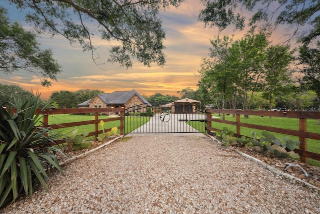 gate at dusk with a lawn and fence
