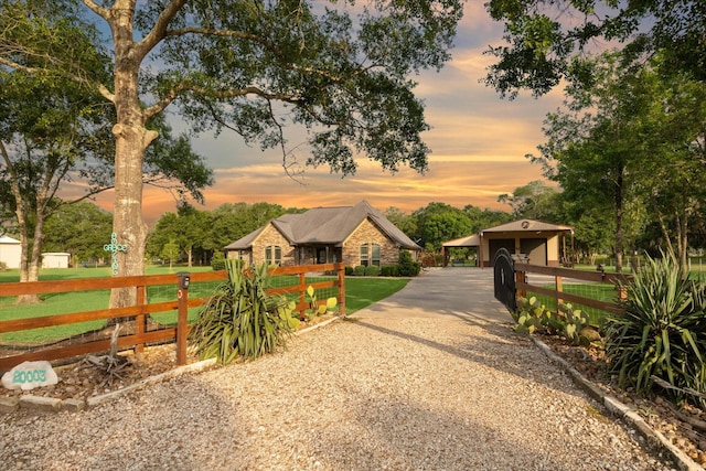 exterior space featuring an outdoor structure, fence, driveway, a yard, and a carport