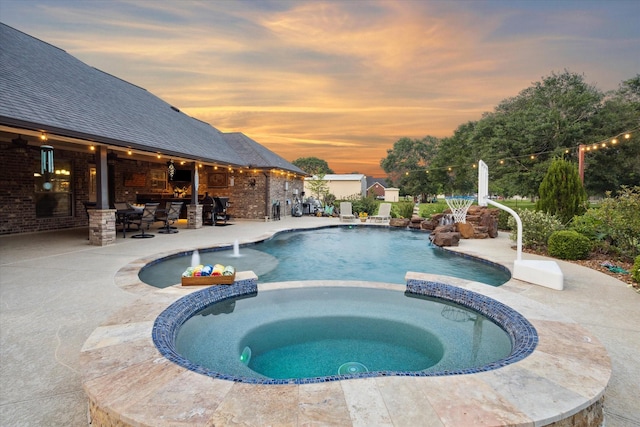 view of pool with a patio and a pool with connected hot tub