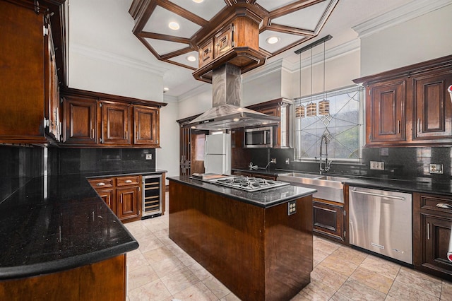 kitchen with appliances with stainless steel finishes, a sink, beverage cooler, a center island, and ornamental molding