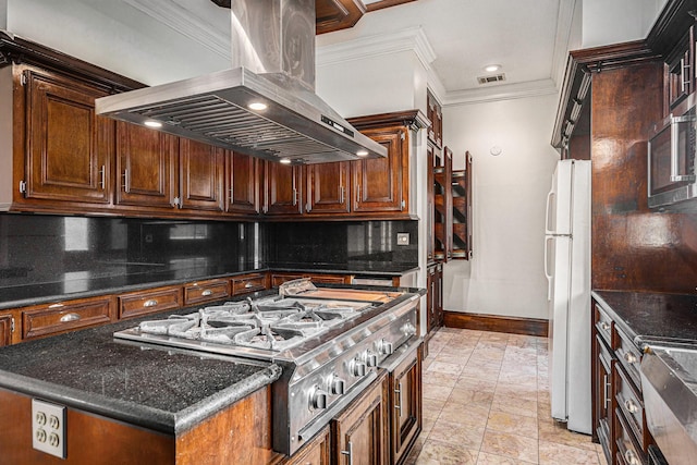 kitchen featuring visible vents, baseboards, island range hood, a center island, and appliances with stainless steel finishes