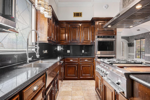 kitchen featuring appliances with stainless steel finishes, a sink, backsplash, visible vents, and ornamental molding