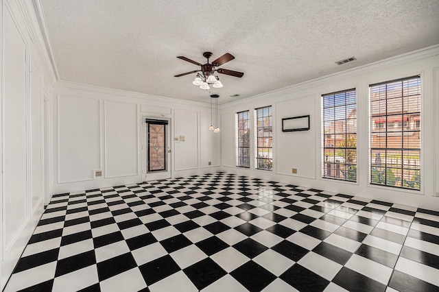 unfurnished room featuring visible vents, ornamental molding, a decorative wall, a textured ceiling, and a ceiling fan