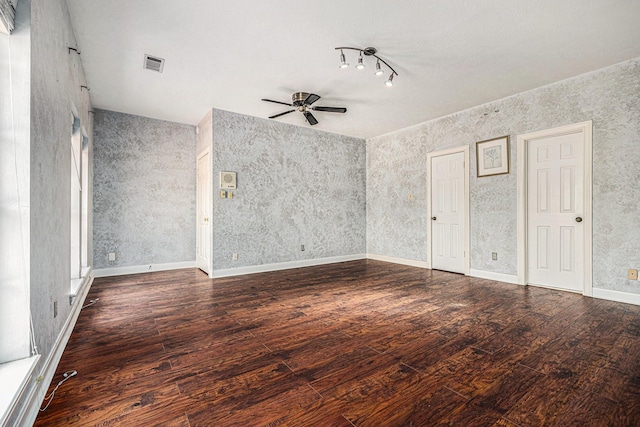 spare room with wood-type flooring, a ceiling fan, rail lighting, and visible vents