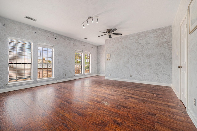 empty room featuring baseboards, a ceiling fan, wood finished floors, and visible vents