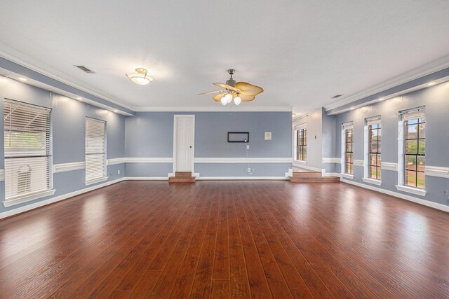 unfurnished living room with ceiling fan, visible vents, baseboards, ornamental molding, and dark wood-type flooring