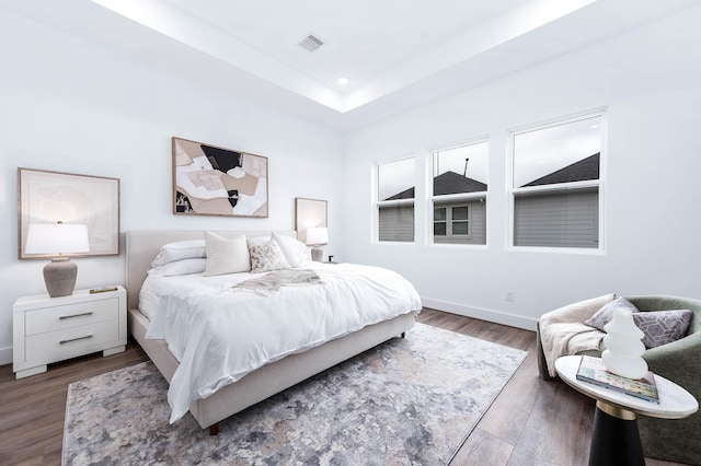 3515 Mcilhenny St, Houston, TX 77004 - bedroom featuring visible vents, wood finished floors, baseboards, a tray ceiling, and recessed lighting