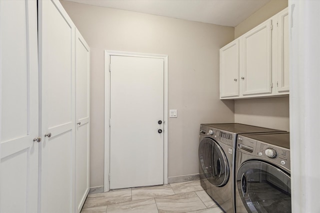 214 Sugarberry Cir, Houston, TX 77024 - clothes washing area featuring washing machine and clothes dryer, baseboards, marble finish floor, and cabinet space