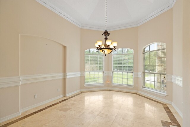 unfurnished dining area featuring crown molding, baseboards, an inviting chandelier, and a high ceiling