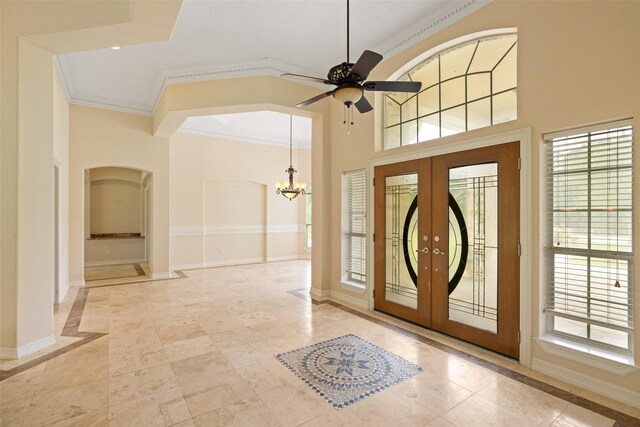foyer featuring french doors, arched walkways, and baseboards