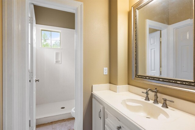 full bathroom featuring vanity, toilet, and a stall shower