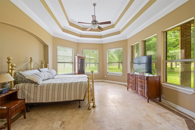 bedroom featuring baseboards, ornamental molding, and a tray ceiling