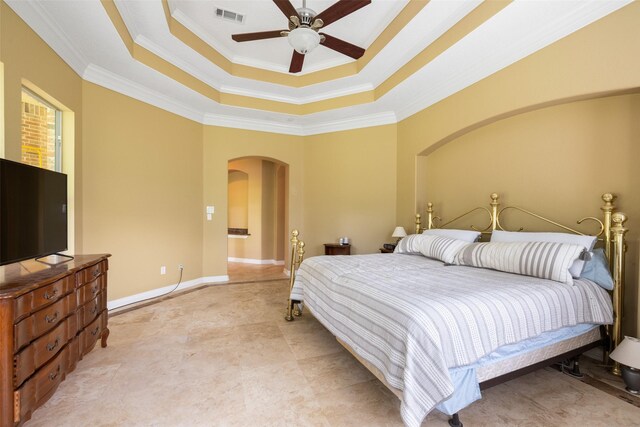 bedroom featuring visible vents, crown molding, ceiling fan, a tray ceiling, and arched walkways