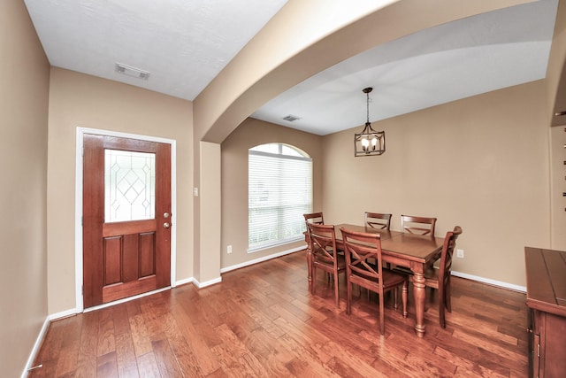 7603 Chimney Gap, Missouri City, TX 77459 - dining area with arched walkways, baseboards, visible vents, and hardwood / wood-style floors